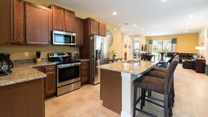 A spacious kitchen with granite countertops, stainless steel appliances, and wooden cabinets. - Fantastic vacation with a private pool - FENCED POOL - Pet friendly (Kissimmee)