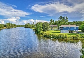 Uma propriedade à beira do lago com casa, um píer e um gramado.