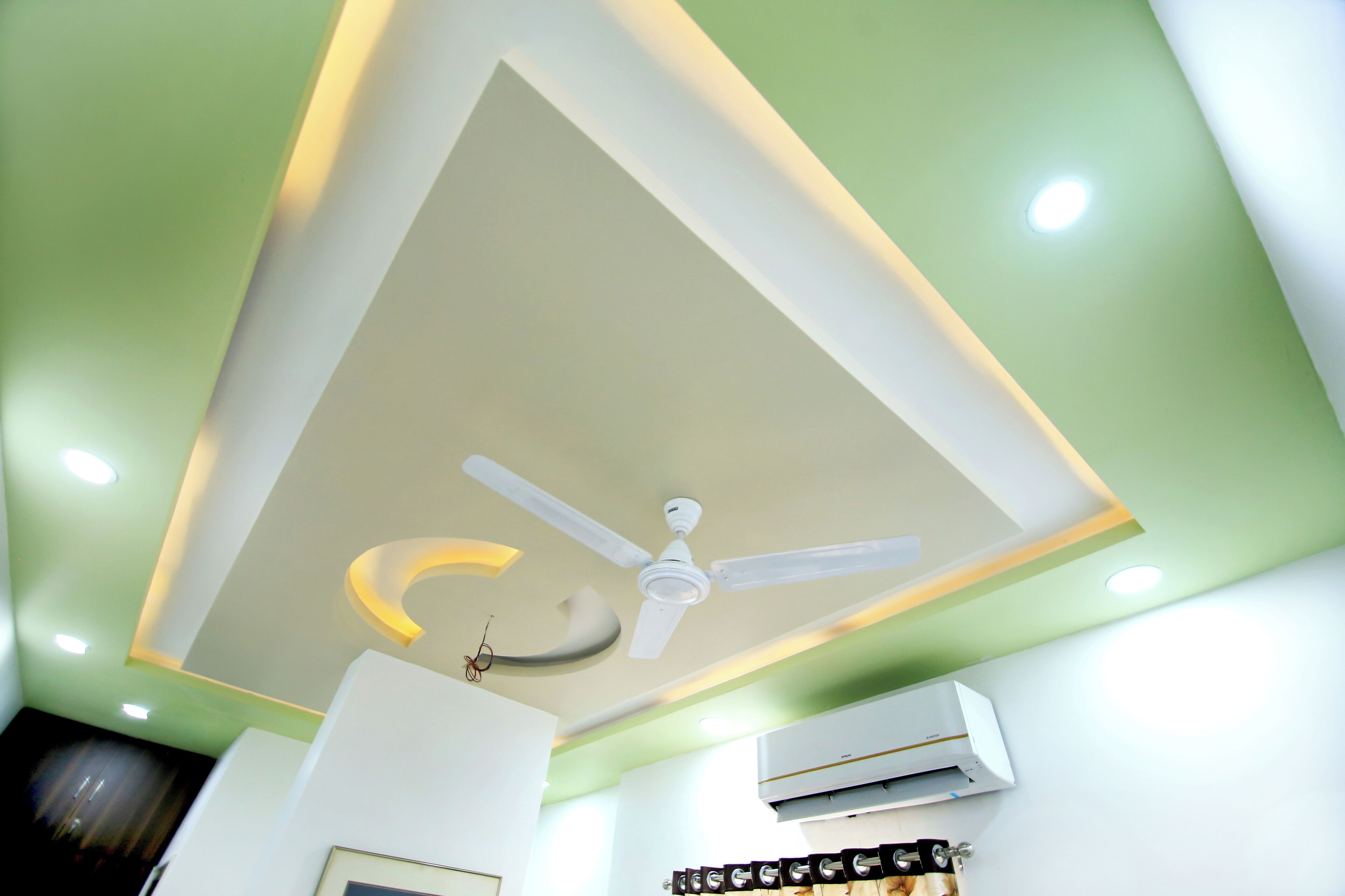 Una habitación con ventilador de techo, luces empotradas y aire acondicionado.