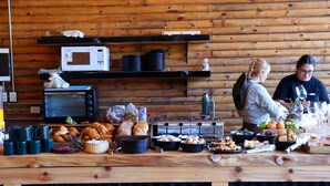 A buffet setup with various food items and kitchen appliances. - Terranova Glamping (Luján)