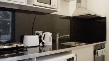 A modern kitchen with a microwave, toaster, kettle, sink, and Bosch dishwasher.