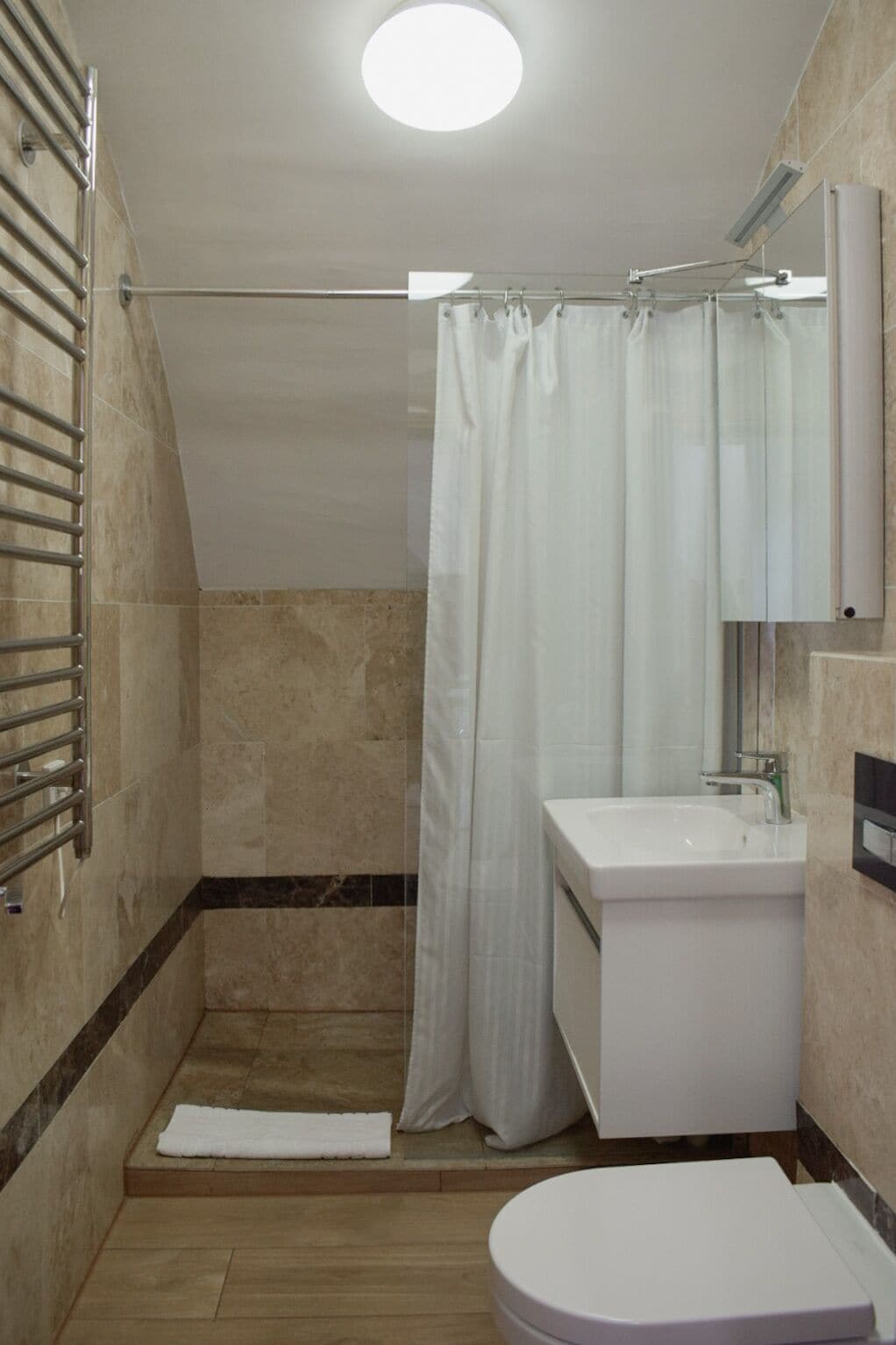 A modern bathroom with a shower, toilet, and sink.