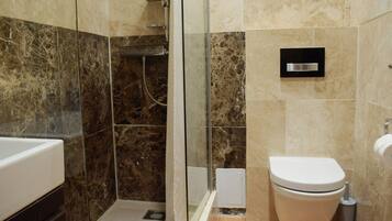 Un baño con ducha, inodoro y lavamanos.