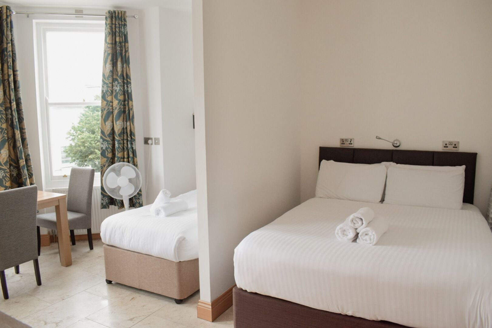 Habitación de hotel con una cama, un escritorio y una silla.