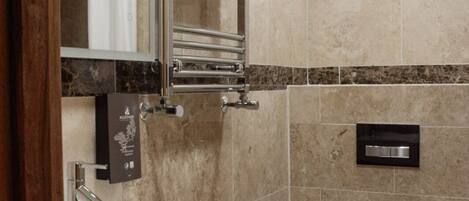 A modern bathroom with a large sink, a mirror, a towel rack, and a toilet.