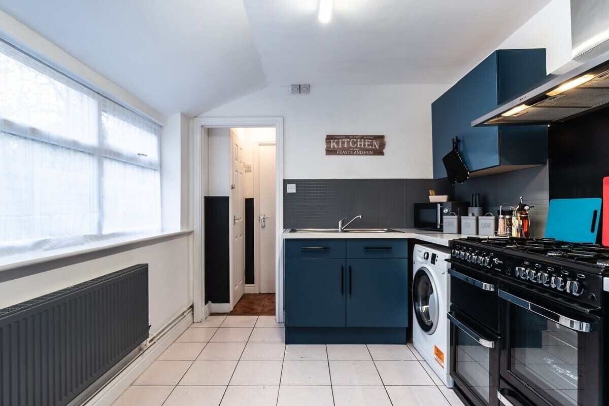 A modern kitchen with a built-in washing machine, a stove, and a microwave.