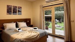 Une chambre à coucher comprenant un lit, une table de chevet, une fenêtre avec des rideaux et un appareil de climatisation.