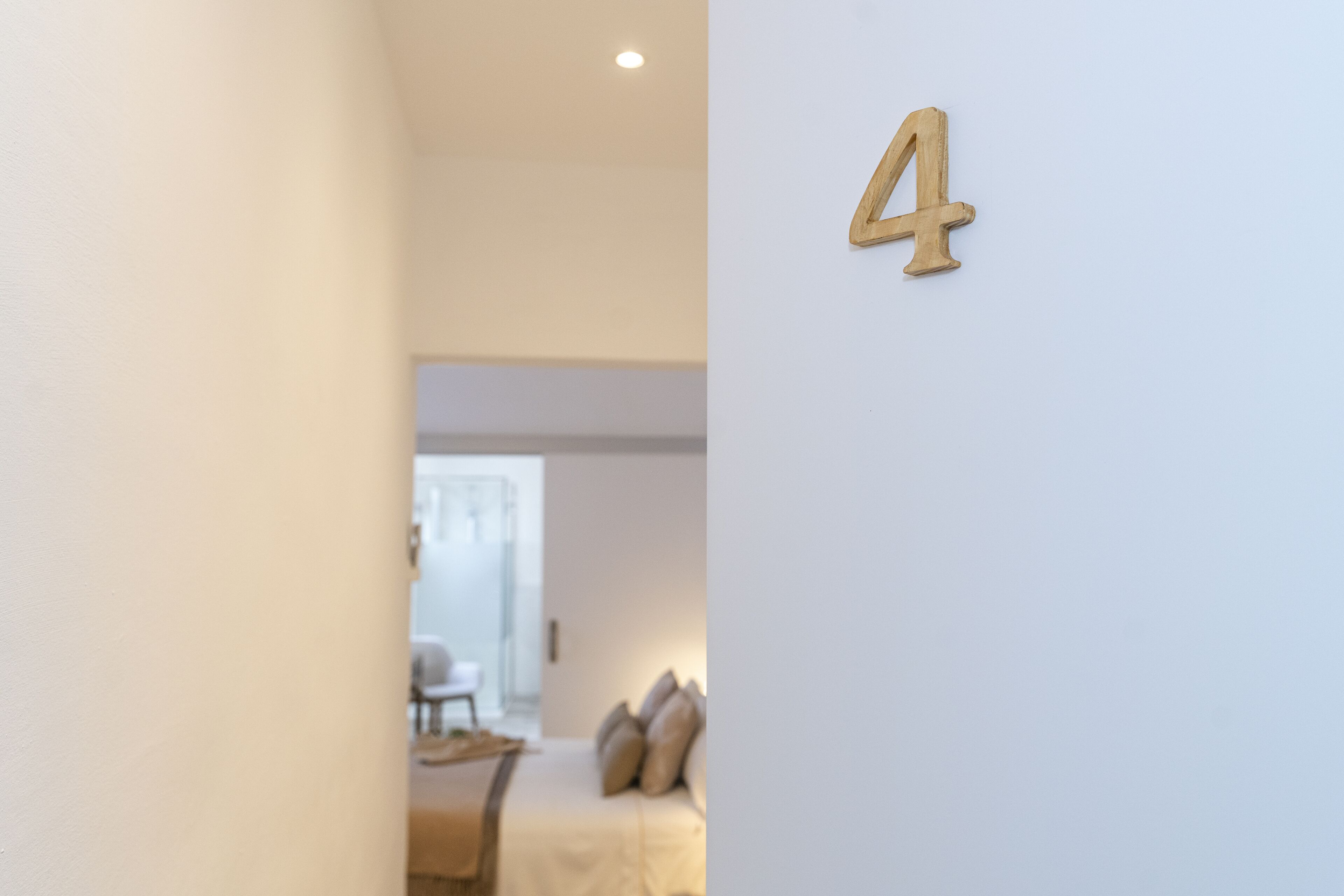 Una habitación con el número 4 en la pared, un sofá y una silla al fondo.