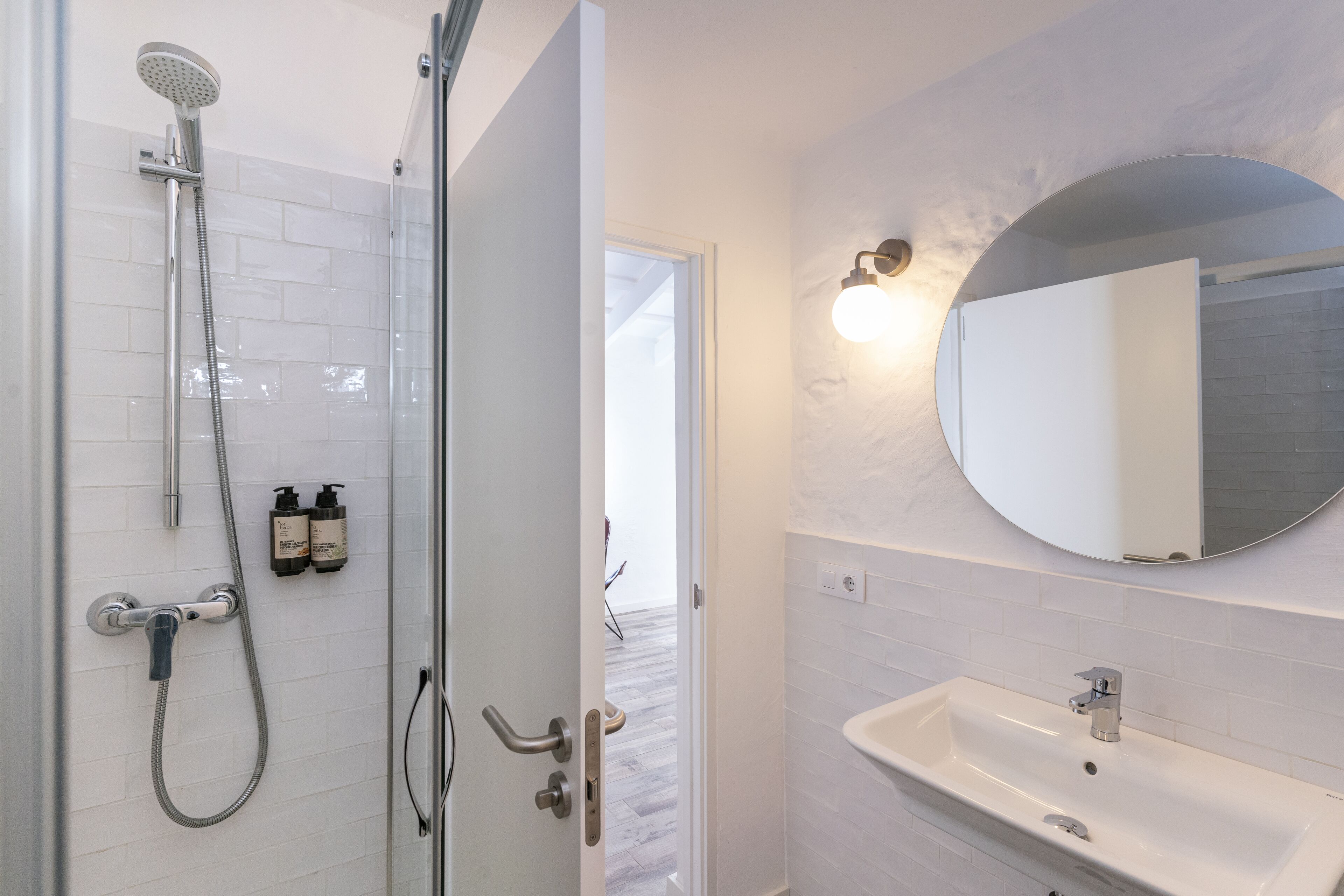A bathroom with a shower, sink, and mirror.