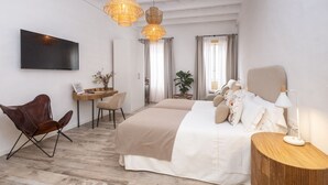 A modern hotel room with a large bed, a desk, a chair, and a television. - Encant de Alaior Boutique Hotel  (Alayor)