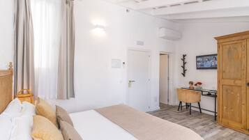 A bedroom with a bed, curtains, a desk, a chair, and a wardrobe.
