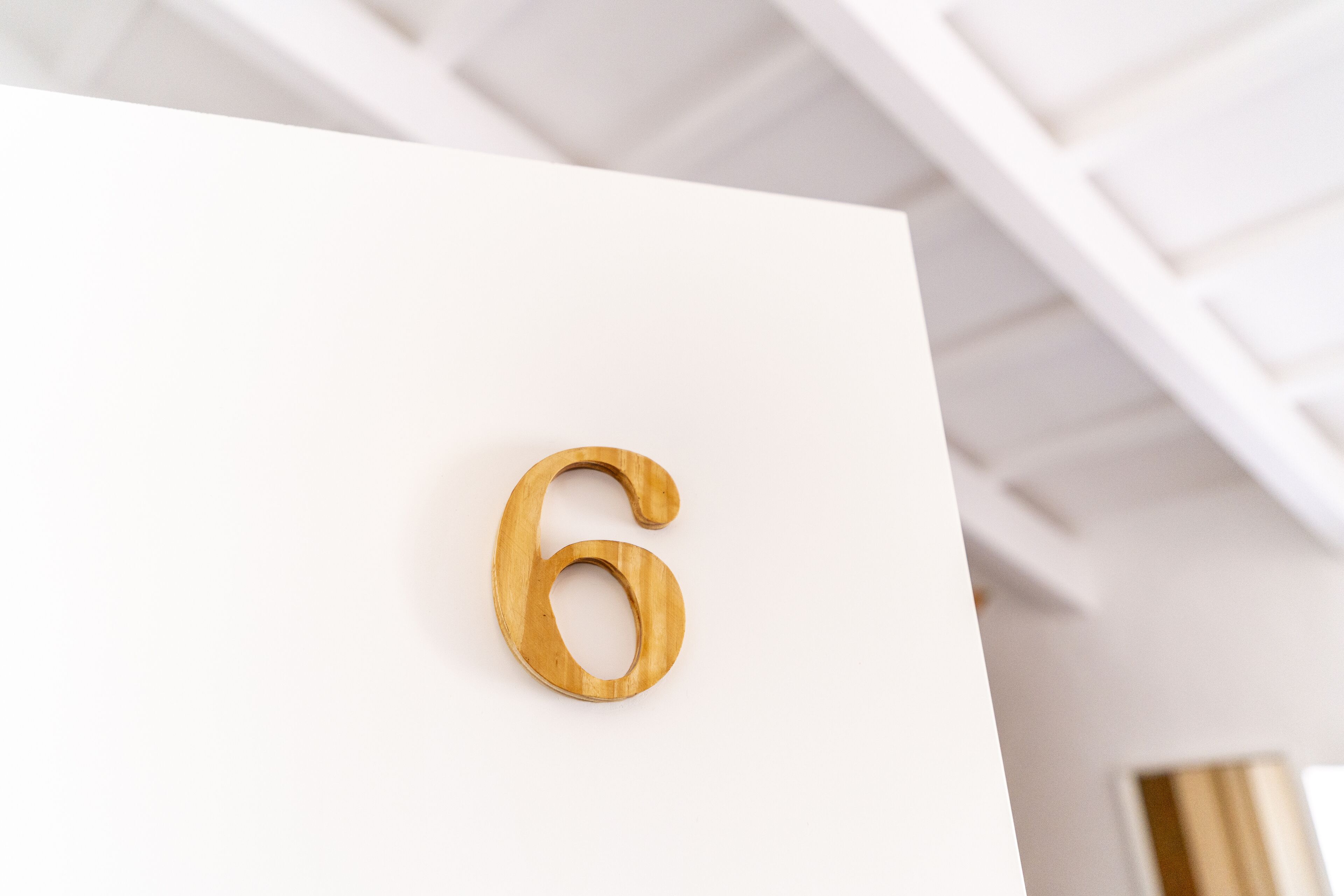 A wooden number '6' on a white background.