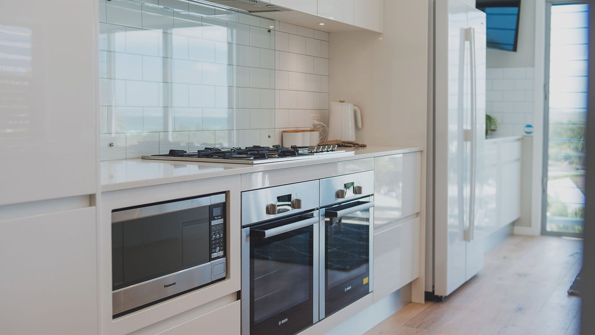 A modern kitchen with a built-in oven, microwave, and a stove.