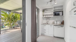 A modern kitchen with white cabinetry, a microwave, and a toaster.