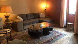 Un salon avec un canapé, une table basse, une lampe de table et un lampadaire.