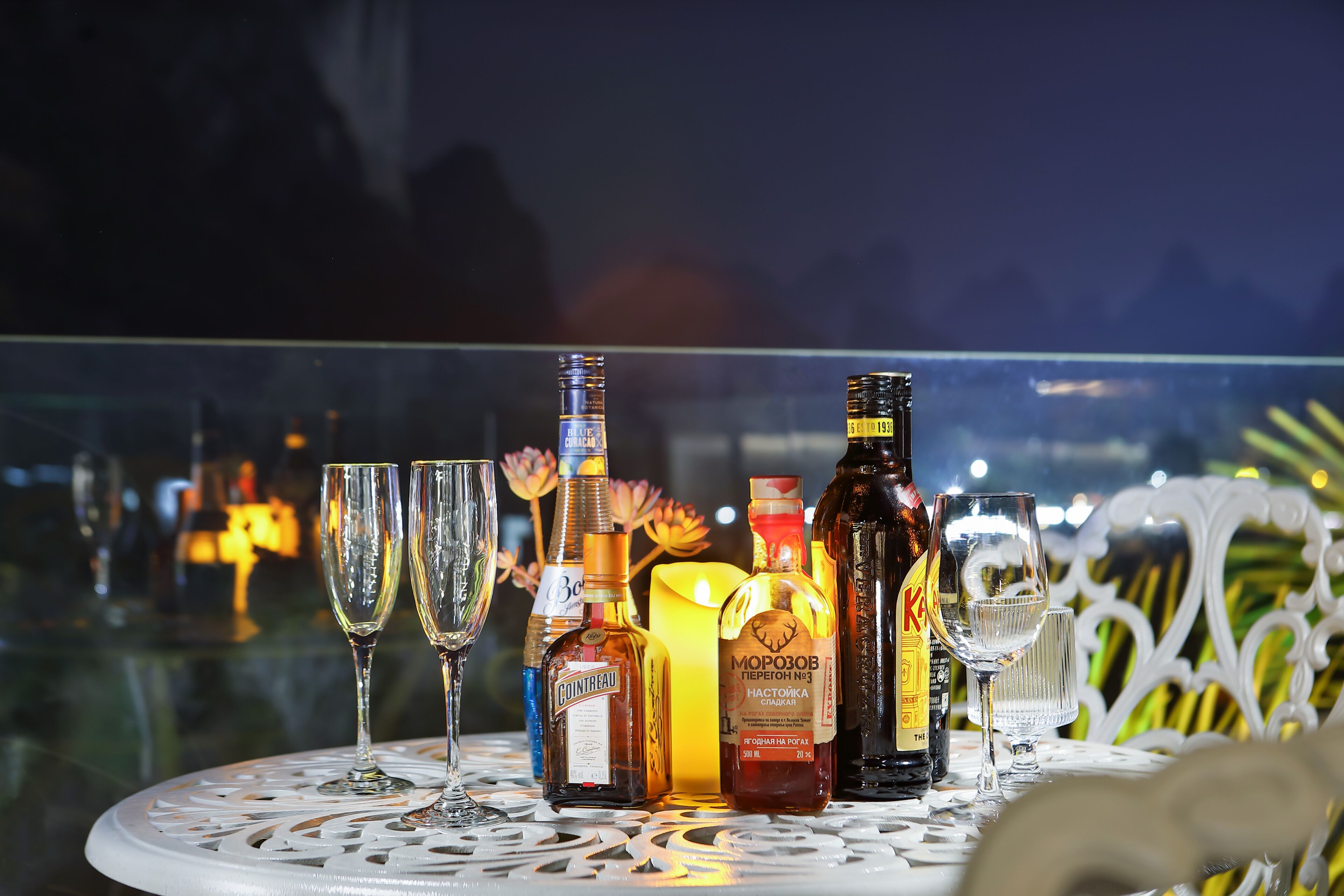 A table with various bottles and glasses, likely for a social event.
