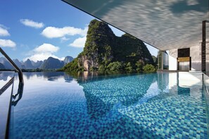 A clear view of a swimming pool with a mountainous landscape in the background.