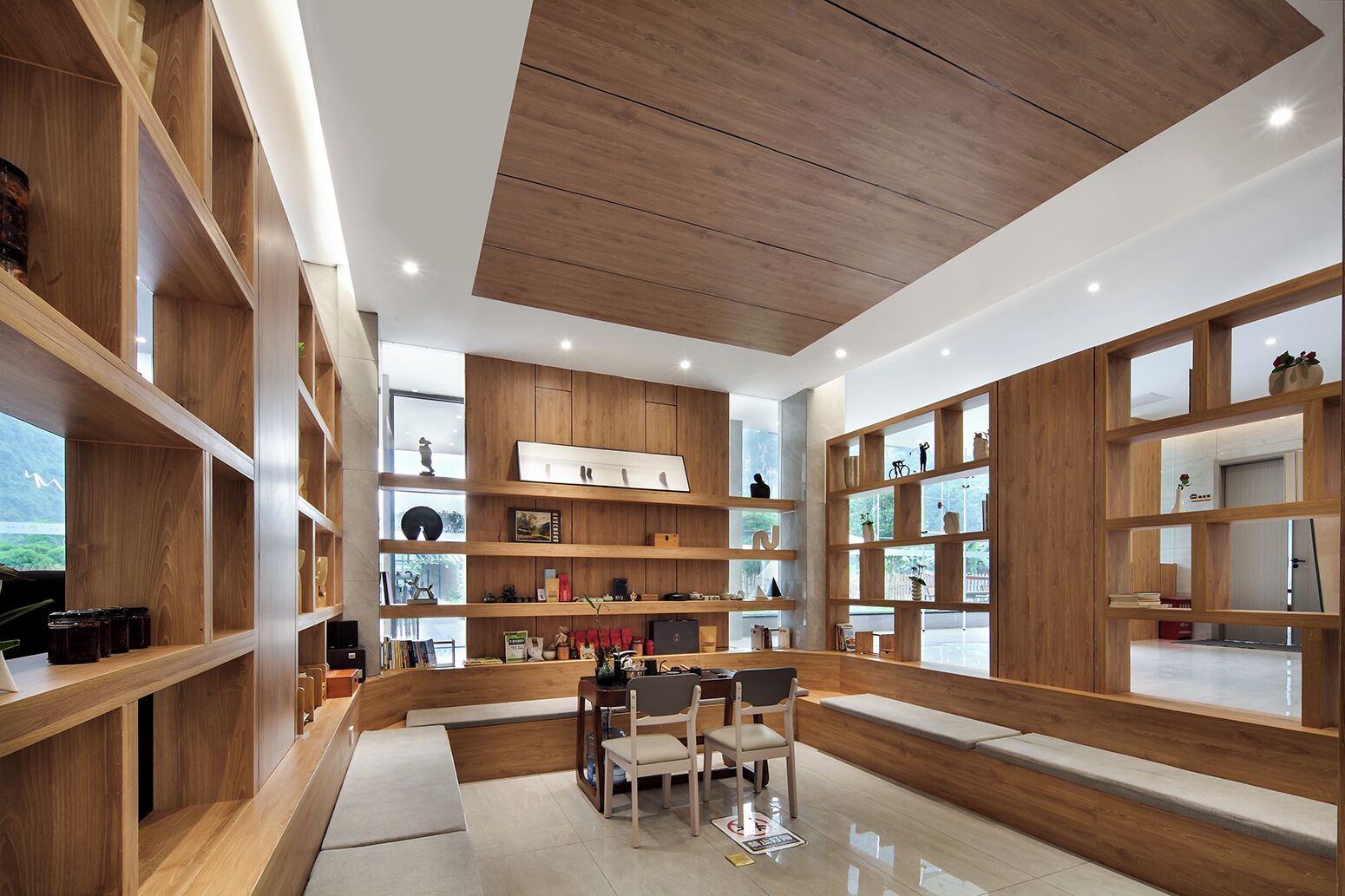 A modern interior with wooden shelving, a seating area, and a view through large windows.