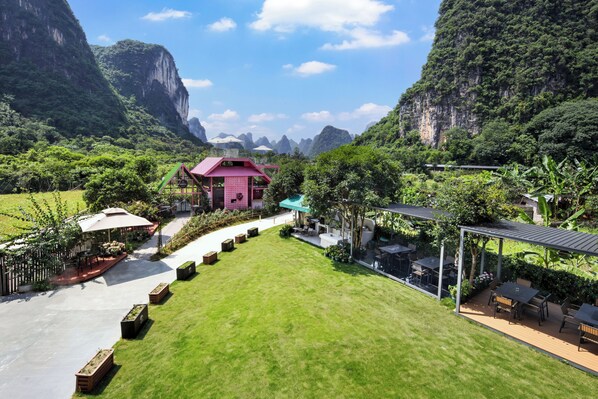 A courtyard with a gazebo, outdoor seating, and a view of a mountainous landscape.