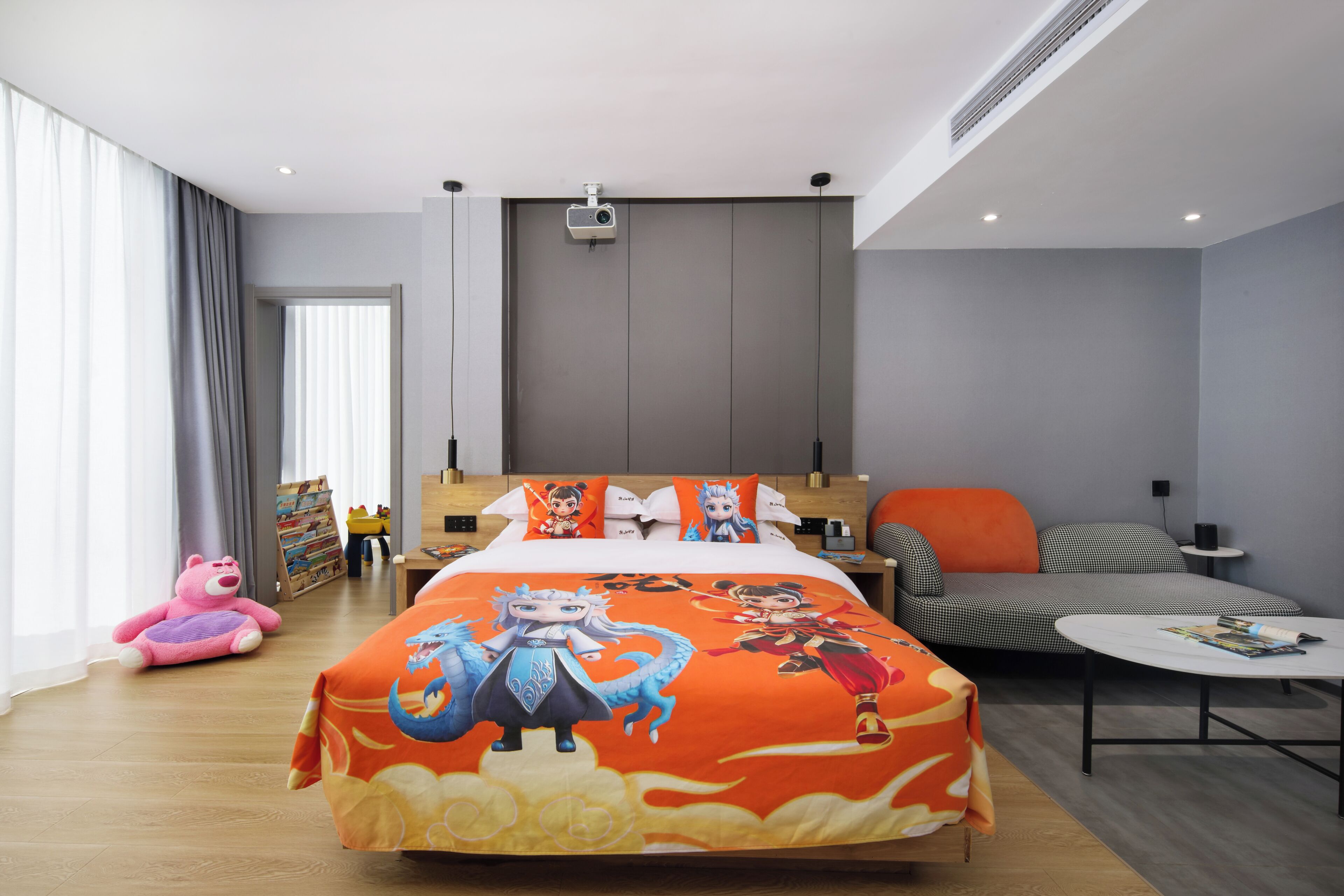 Quarto de hotel moderno com cama, sofá, mesa de centro e uma janela grande.