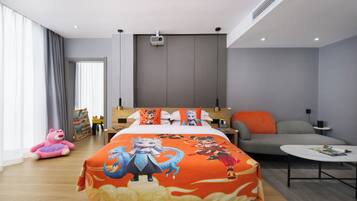 Quarto de hotel moderno com cama, sofá, mesa de centro e uma janela grande.