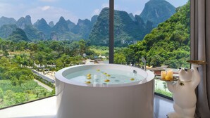 A bathtub with a scenic view of mountains and greenery. - Yangshuo Fairyland Hotel (Guilin)