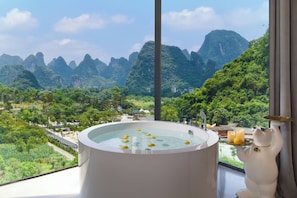 Una bañera con una vista panorámica de montañas y vegetación.