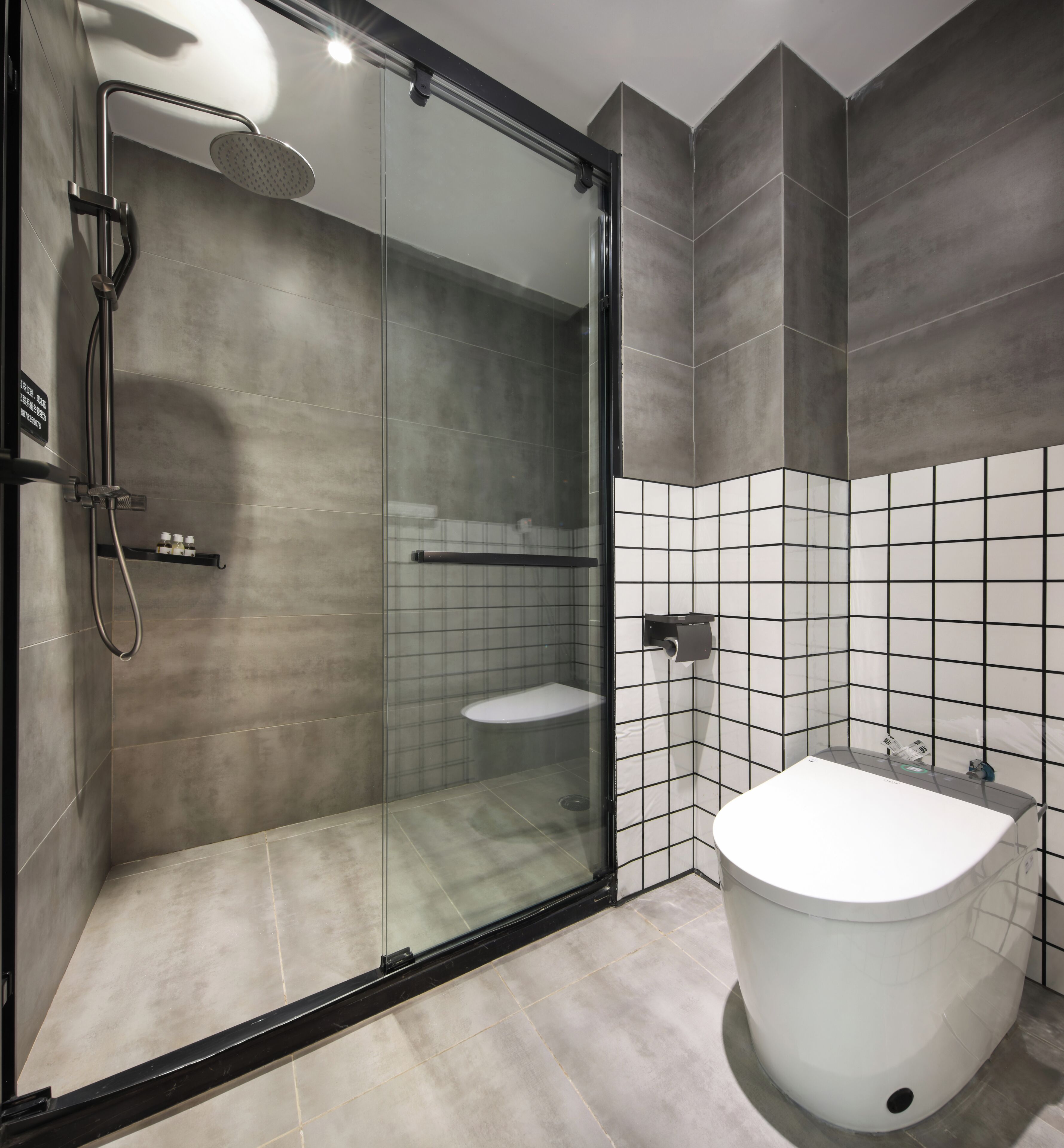 A modern bathroom with a glass-enclosed shower, a white bathtub, and a tiled wall.