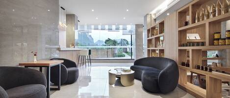 Un salon moderne avec une grande fenêtre, une bibliothèque et deux canapés.