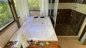 Shower, bathtub dengan aliran air, pengering rambut, dan handuk
