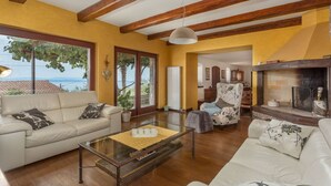 A living room with a sofa, armchair, and a fireplace. - Villa Karla, pool with beautiful sea view (Opatija)