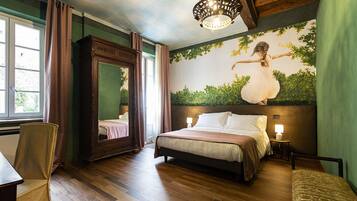 A bedroom with a large bed, a mirror, a chandelier, and a mural on the wall.