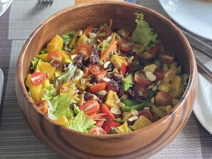 A wooden bowl filled with a colorful salad.