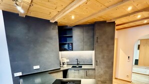 A modern kitchen with a central island, built-in microwave, and a sink. - Residence Palmai (Castelrotto)