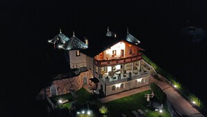 A two-story building with a balcony and a well-lit outdoor area. - Residence Palmai (Castelrotto)