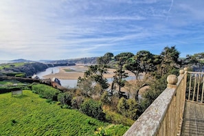 A coastal landscape with a wooden walkway, lush greenery, and a river. - White Horses Bantham South Devon (Bantham)