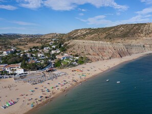 A coastal town with a beach, houses, and cliffs.