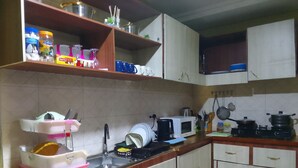 Una cocina con microondas, estufa, fregadero y diferentes utensilios de cocina.