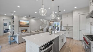 A modern kitchen with a central island, stainless steel appliances, and pendant lighting. - Close to the Clubhouse with Bikes and LSV (Santa Rosa Beach)