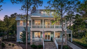 A two-story house with a front porch, a flag, and a staircase leading to the entrance. - Close to the Clubhouse with Bikes and LSV (Santa Rosa Beach)