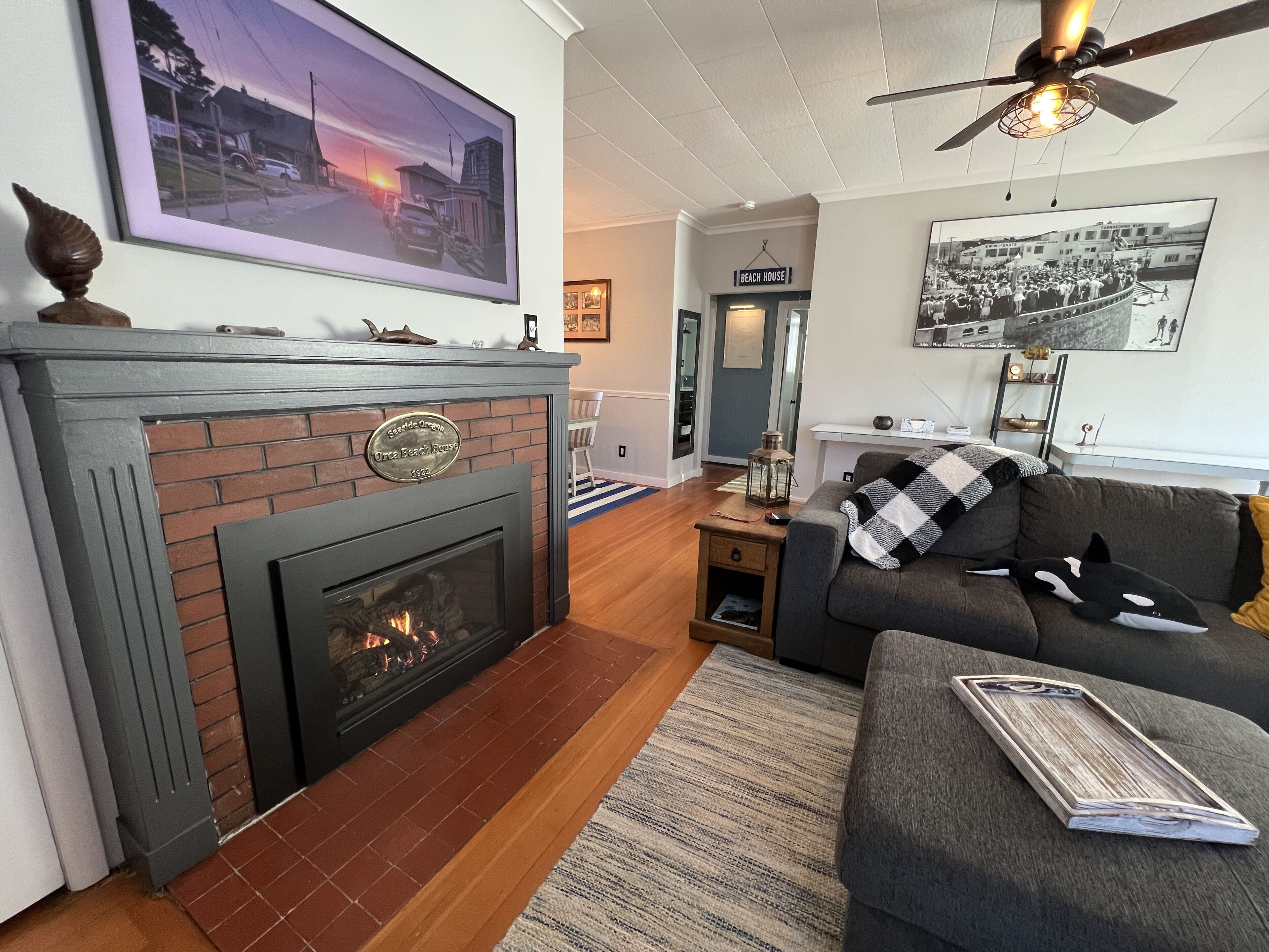 A living room with a fireplace, a sofa, a coffee table, and a ceiling fan.