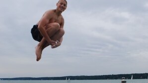 A person mid-air above a body of water with boats in the background. - Seebrise Type B3, Holiday home Seebrise, FW Type B (Storkow (Mark))