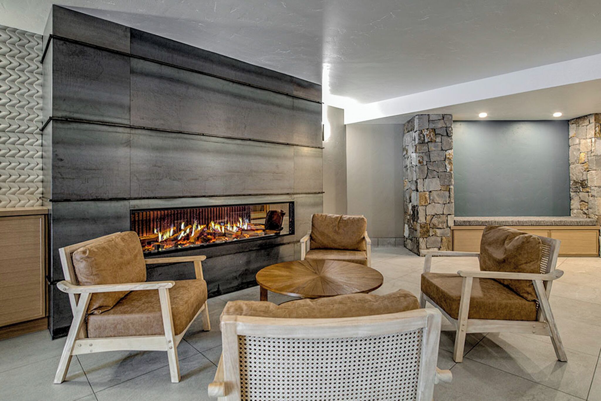 Una sala de estar moderna con una pared de acento de piedra, chimenea y asientos cómodos.