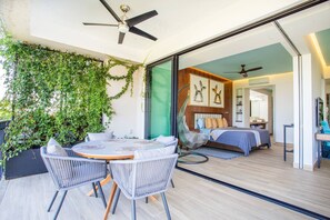 Ein modernes Interieur mit Essbereich, einem Bett und Blick durch eine Glasdoor.