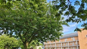 A building with a brick facade, multiple windows, and a flat roof. - Kurparkcarree - Apartment "Meeresbrise" (Ostseebad Juliusruh)