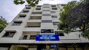 A multi-story building with a sign for Nevesa Inn, Hotel Apart. - Hotel Nevesa Inn (Bengaluru)