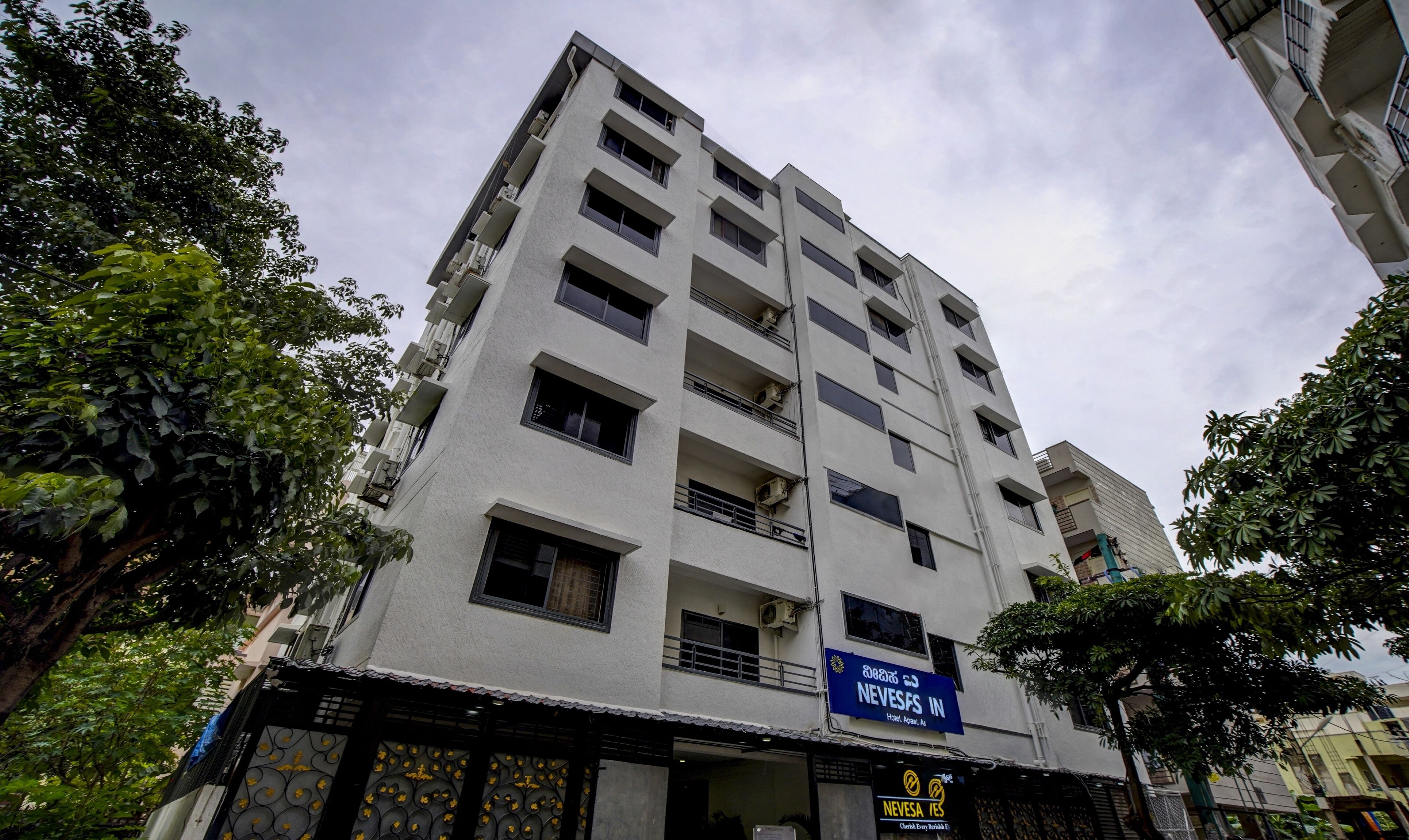 A multi-story hotel with balconies and a blue sign indicating 'NEVES IN Hotel, Appu, A1'.