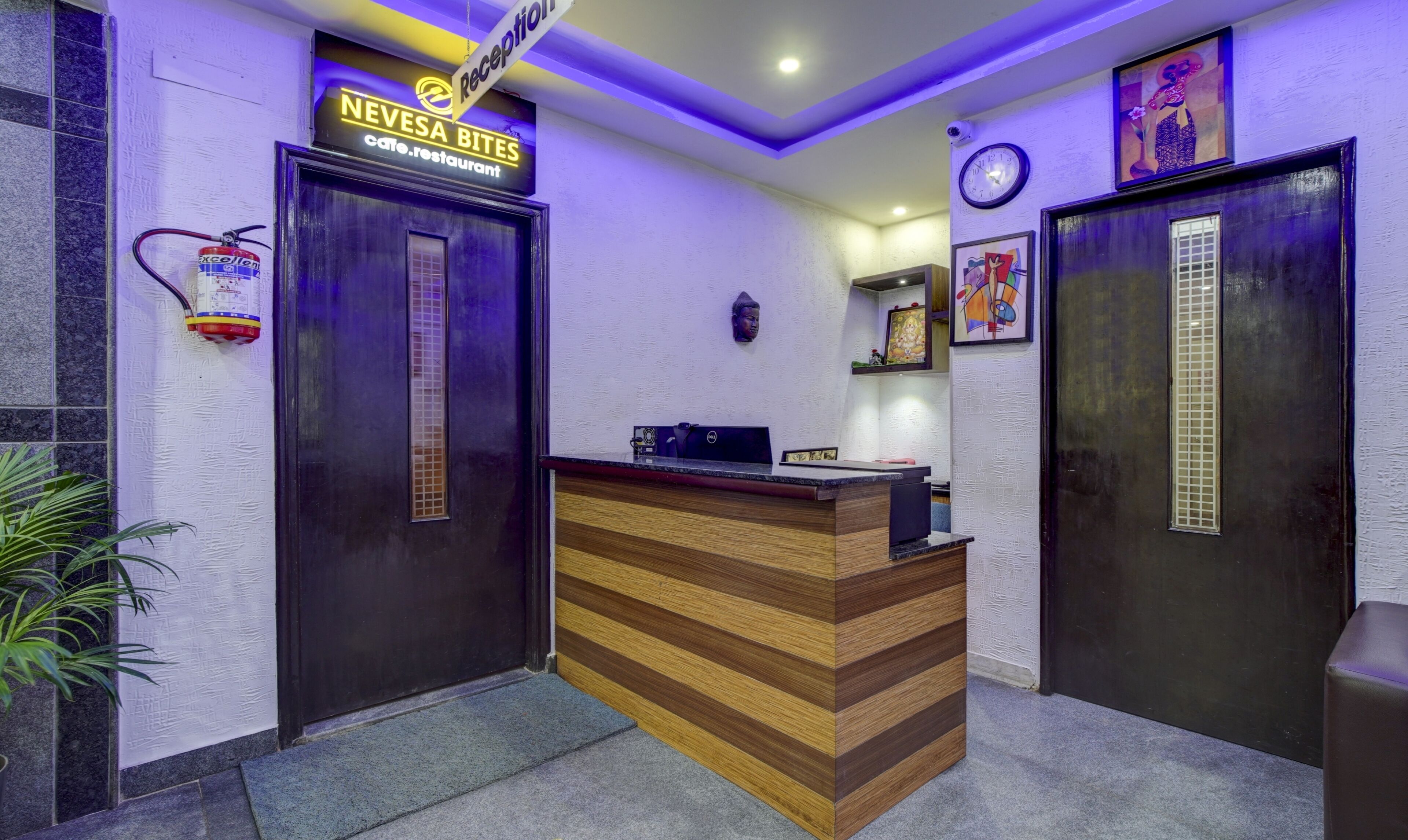A reception area with a wooden reception desk, a reception sign, a clock, and a fire extinguisher.