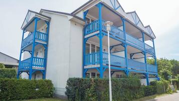 A multi-story building with blue balconies and a white facade.