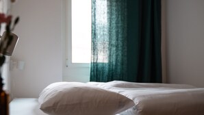 A bedroom with a bed, a window with curtains, and a book on the bedside table. - Bogentrakt - Hostel (Chur)